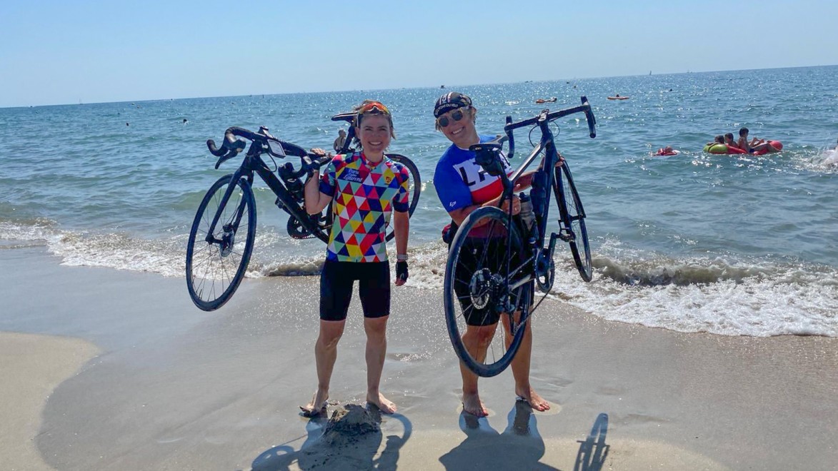 Two female cyclists having arrived with their bike on the beach of Sète, at the end of an epic cycling adventure.