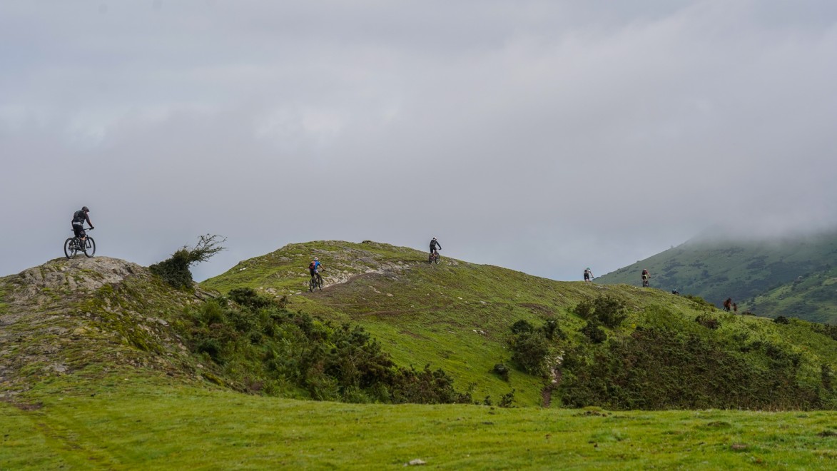 Mountain bikers on a foggy ridge in the Pyrenees.