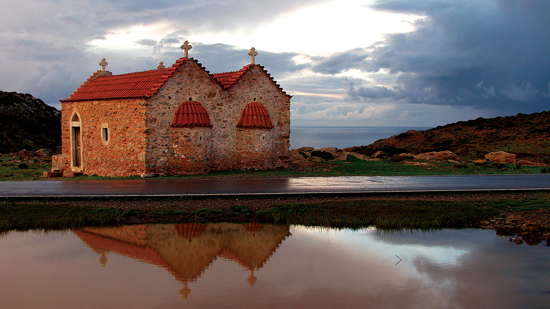 a Greek Orthodox church reflected in the water
