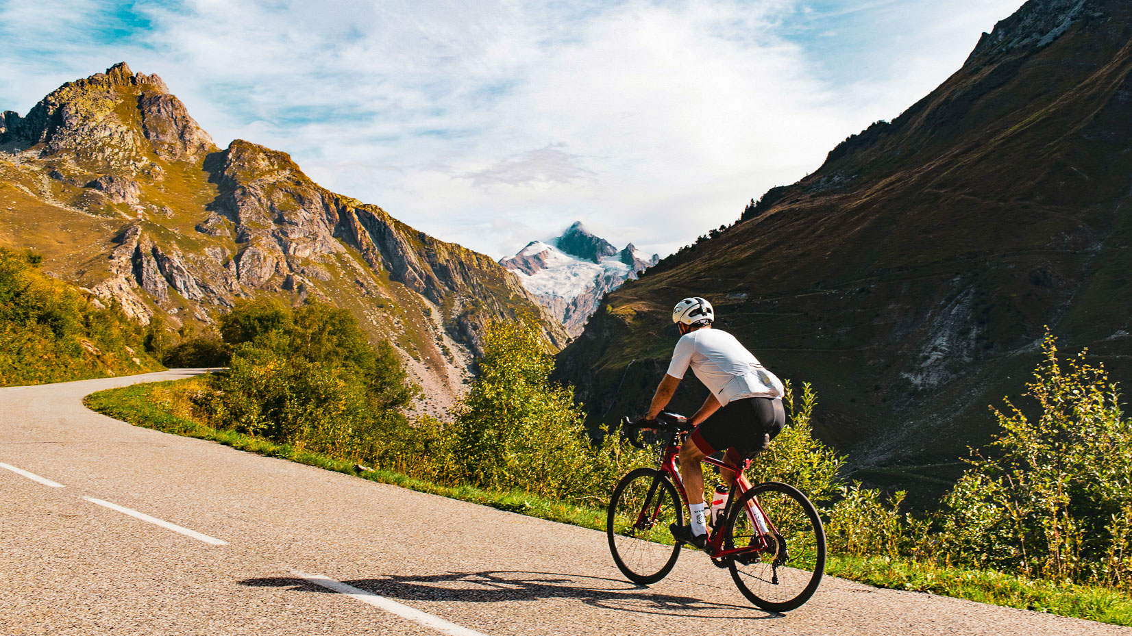 cyclist climbing an iconic pass with the view over the Aiguille des Glaciers