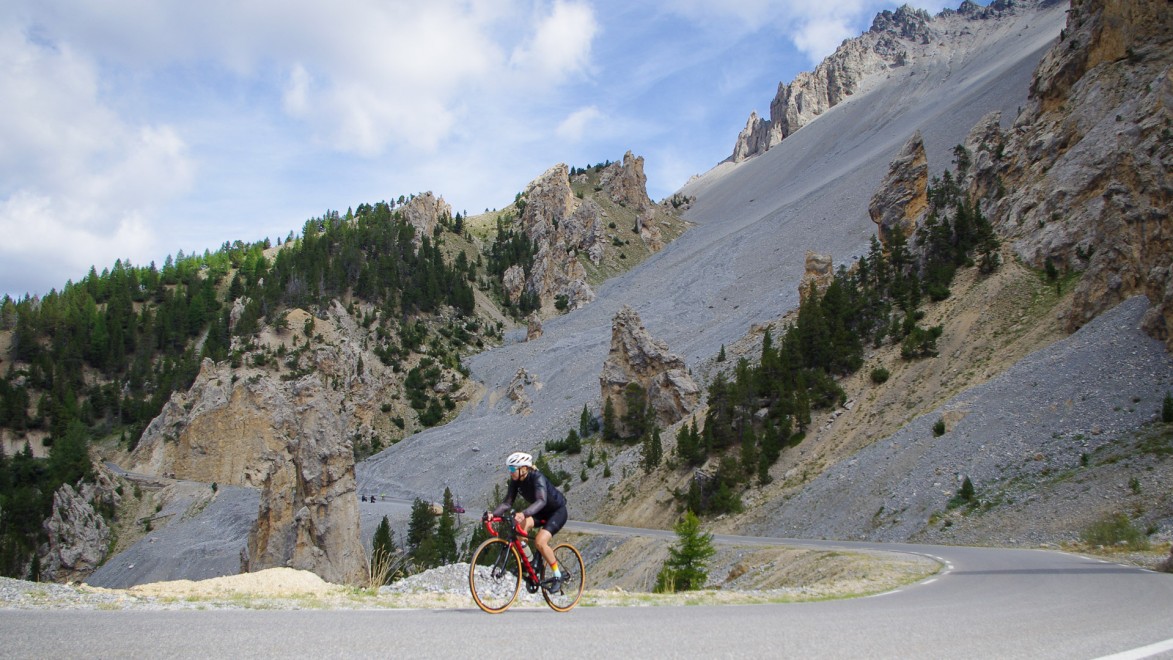 a road cyclist climbing le col de l'Izoard in southern Alps from the Queyras side, lunar ambience around the iconic Casse Déserte