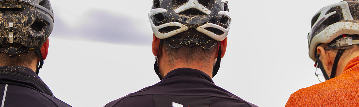 Three men seen from behind after a gravel ride on a rainy day